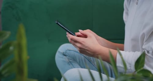 Woman Using Cell Phone Inside, Scrolling on Screen