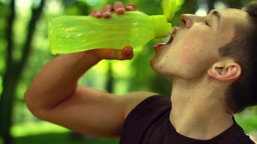 Sport Man Drinking Water From Bottle. Cold Drink After Outdoor Fitness. Young