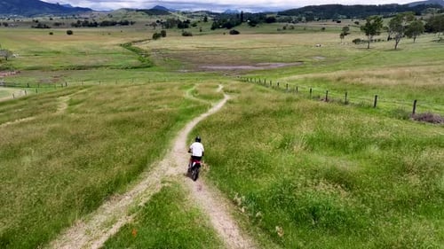 Dirt Bike Riding Through Green Rural Landscape