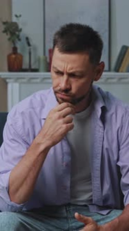 Reflective Man with Books and Plant Pensive Male Figure in Casual Attire Within Comforting Home