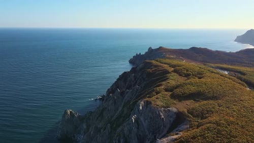 Una vista panorámica de un acantilado junto al océano con vistas infinitas del agua y el cielo