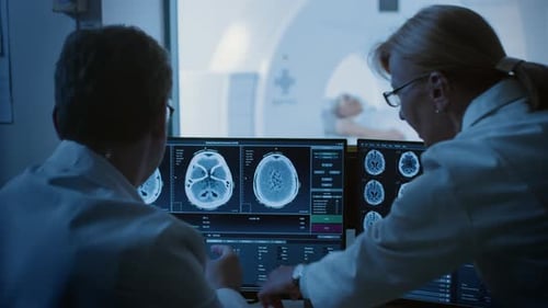 Doctors Analyzing CT Scan Images with Patient in Background