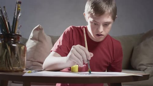 Young Person Painting Indoors at Table with Watercolors