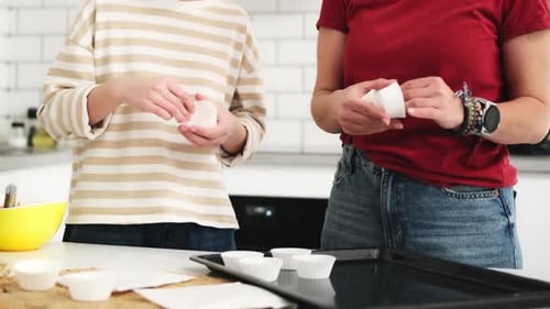 Child and Adult Placing Cupcake Liners