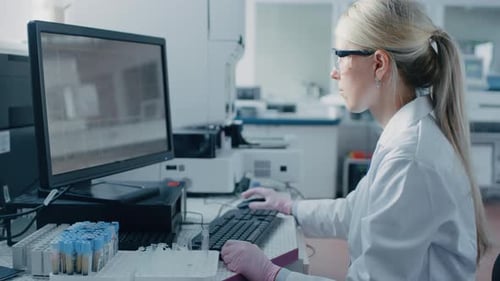 Female Scientist Works with Computer in Medical Lab