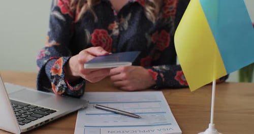 Woman Holds Ukrainian Passport with Visa Application