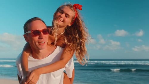 Young Caucasian Friends Fun on Beach Woman Jumps on Man Back