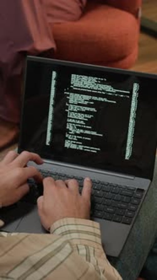 Vertical of Freelance Developer Coding on Laptop in Coworking Space