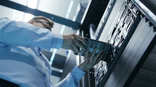 Weitwinkelaufnahme Der voll funktionsfähige IT-Techniker des Rechenzentrums installiert die Festplatte im Server-Rack. Deta