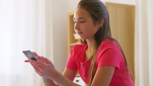 Teenage Girl Using Mobile Phone at Home