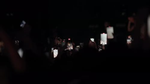 Audience Captures Concert with Phones in Dark Venue