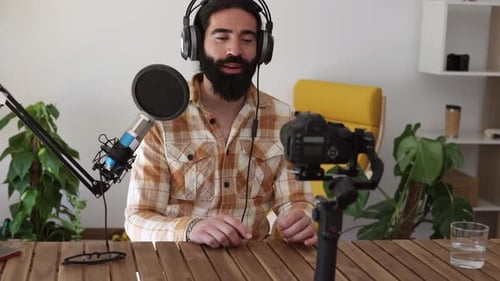 Mann nimmt Podcast im Heimstudio mit Kamera auf