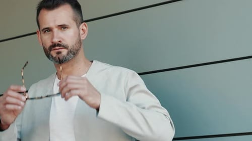 Stylish Man Puts on Sunglasses and Poses