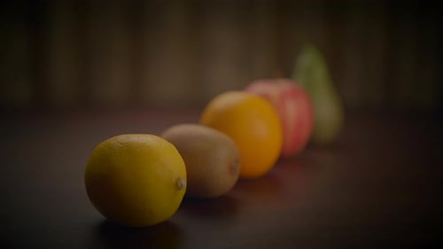 Fruits Lined Up on a Dark Table