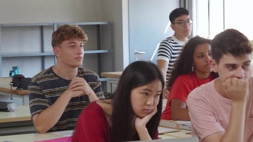 Grupo de estudiantes adolescentes diversos escuchando en clase a los estudiantes del instituto