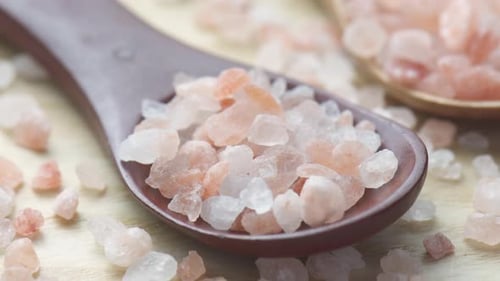 Closeup view of wooden spoons with Himalayan salt crystals