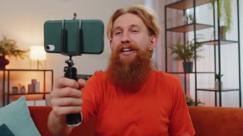 Man with Beard Vlogging with Mobile Phone Indoors