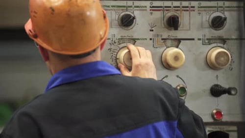 Industrial Worker Operating Machinery in Factory Setting Stock Clip