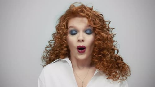 Woman with Curly Red Hair Reacting with Surprise