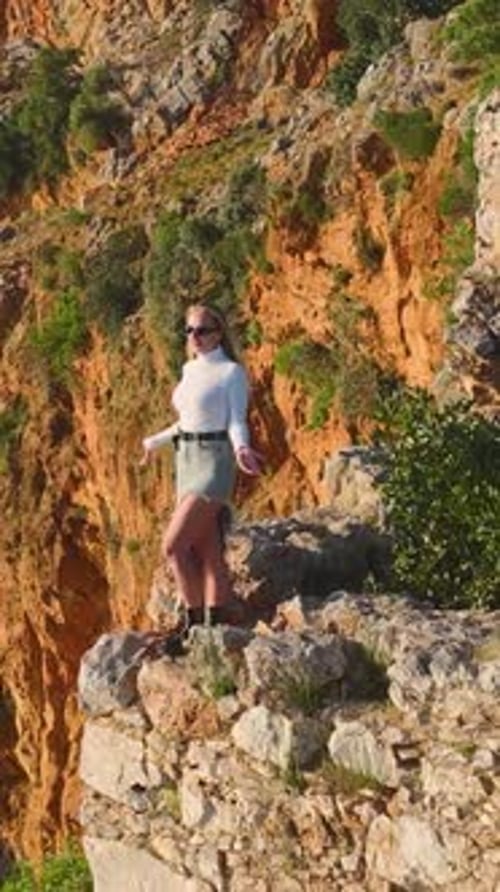Vertical Video Beautiful Model Posing on a High Cliff With a Spectacular Mediterranean View