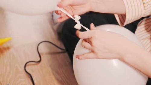 Close Up Tying Two White Balloons Together