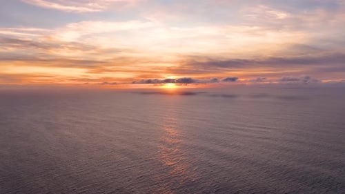 Stunning aerial view of sunset reflecting on calm ocean waters