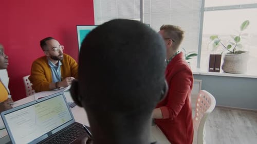 Cheerful Female Manager Talking to Colleagues at Meeting in Creative Agency