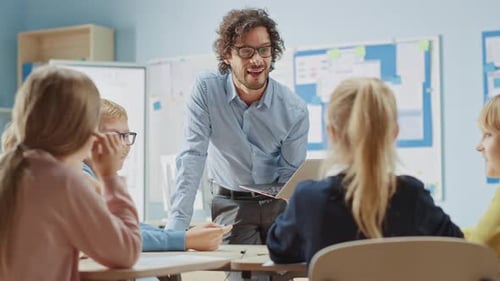 Enthusiastic Teacher Explains Lesson to a Classroom Full of Bright Diverse Children, Leads Class wi