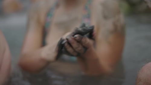 Hands of Adolescent Woman Kneading Mud in Her Hands