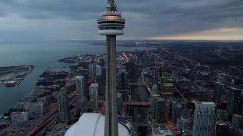 Aerial view around the CN Tower, dark, sunset in Toronto, Ontario, Canada - circling, drone shot