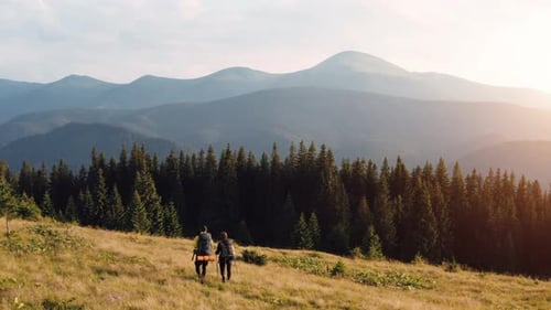 Couple of tourists walks up on hill. Majestic Carpathian Mountains. Beautiful landscape of untouched