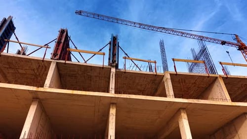 Fuera del edificio en el sitio de construcción. Una grúa alta sobre la estructura como telón de fondo.