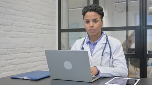 African Female Doctor Smiling at Camera in Clinic