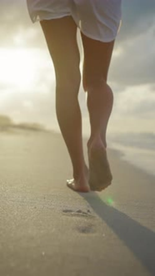 Footprints on Sand Following Shot with Slender Lady Walking on Ocean Shore Female Legs Barefoot