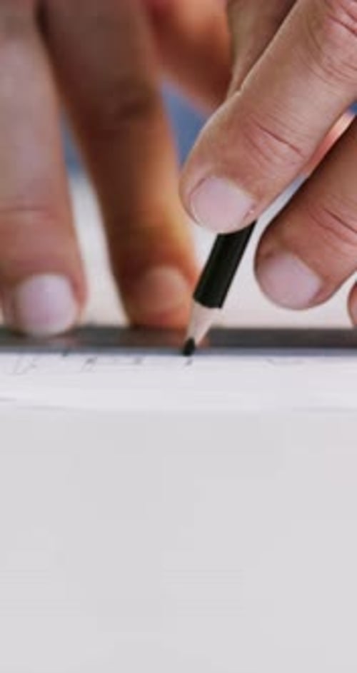 Architect Drawing Technical Plan with Pencil and Ruler