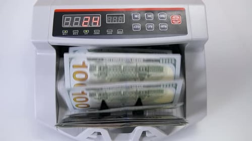 Automatic money counting in the machine. Electronic money machine is counting the dollar banknotes.