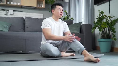 Man Experiencing Knee Pain at Home