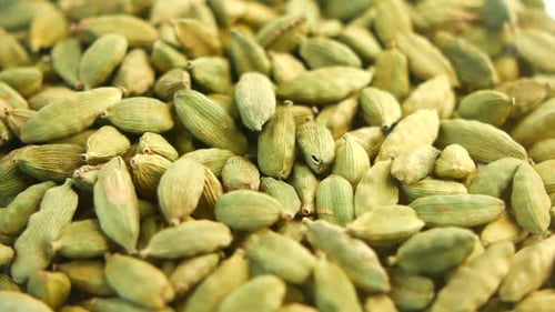 Close Up of Cardamom Falling into Pile