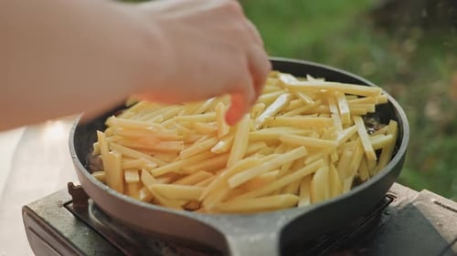 Cooking Outdoors Peacefully Outdoor Cooking Scene with Fries on Stove Prepared Camping Meal of Raw