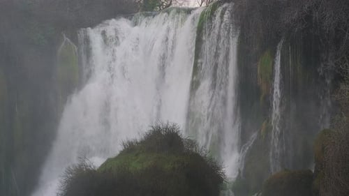 Powerful Waterfall in Misty Forest Landscape