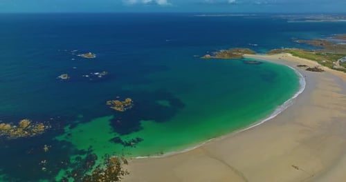 Aerial View of the Tranquil Beach at Plage Des Amiets with Clear Turquoise Water and Waves
