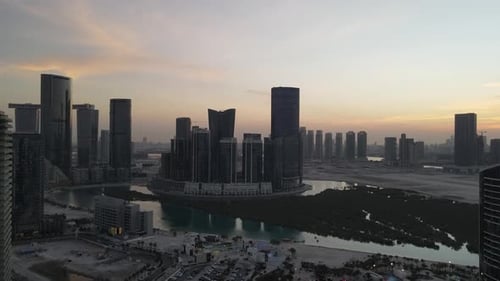 Puesta de sol en Abu Dhabi Vista aérea de la isla de Al Reem rodeada de modernos rascacielos entre