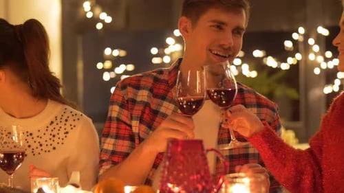 Friends Gather Around Table Clinking Wine Glasses