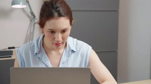 Young caucasian woman sitting and using laptop computer planning for success in office.