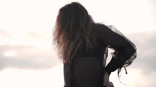 close up of caucasian young female dancer performing on sandy ocean beach during sunset