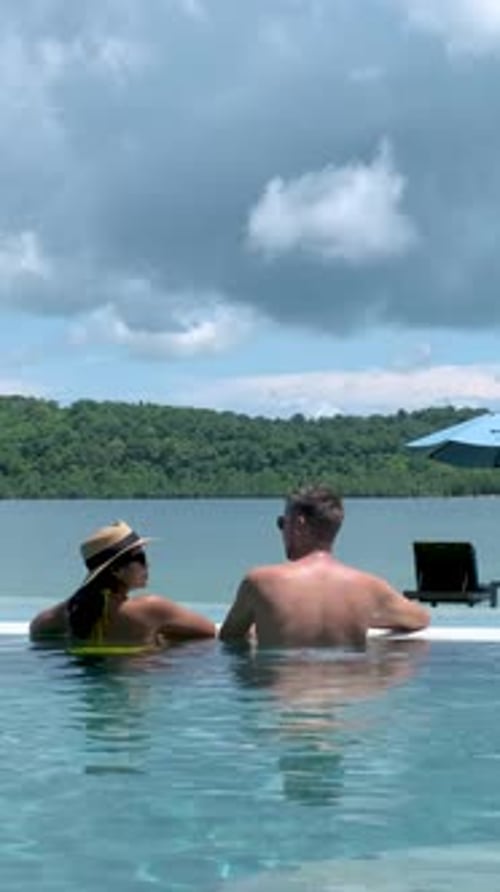 Couple Men and Women Relaxing in a Swimming Pool During Vacation in Thailand
