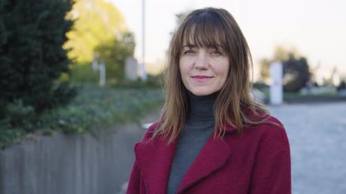 An Attractive Middleaged Caucasian Woman Smiles at the Camera in an Urban Area Ends in Closeup