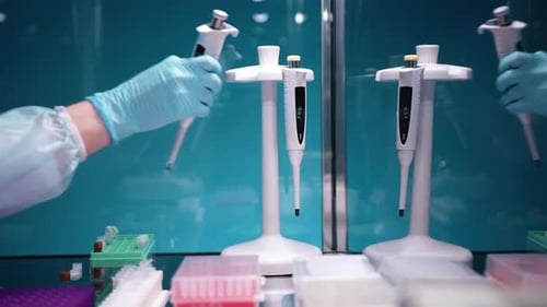Gloved Hand Using Pipette in Science Laboratory