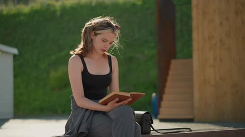 Woman Reading Book Outside on Sunny Day