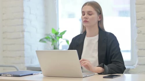 Woman Working on Laptop Stretches Sore Neck